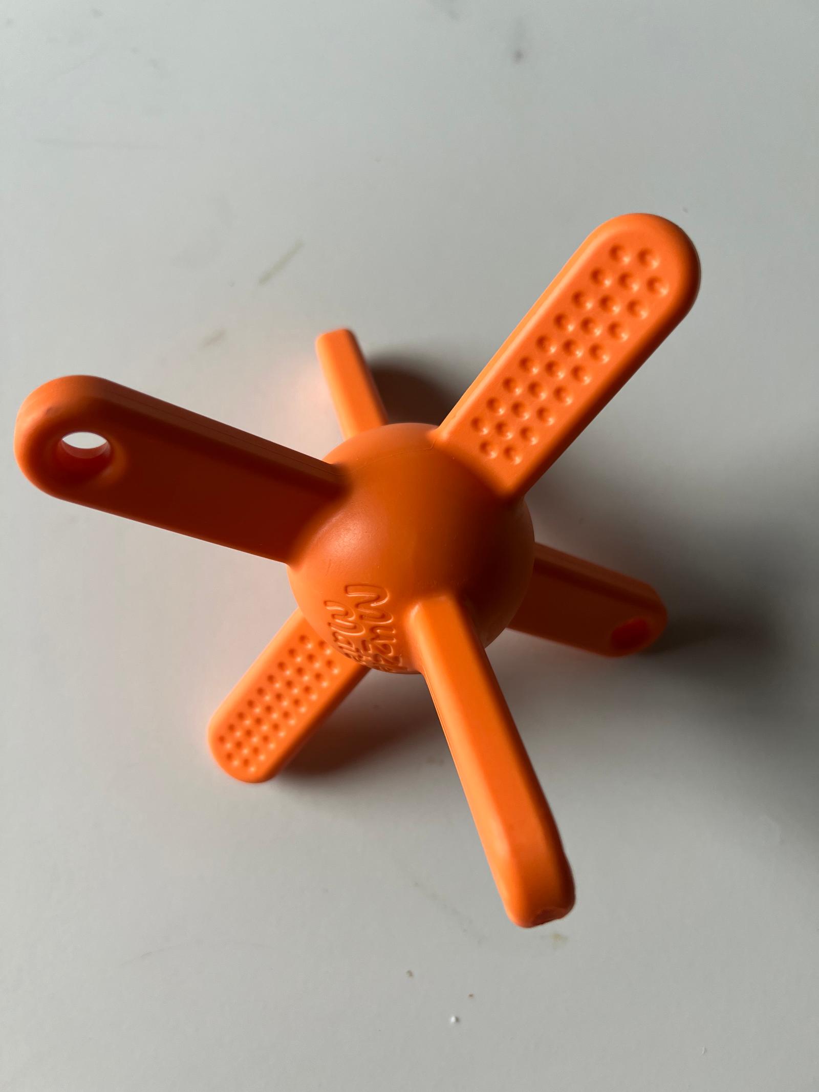 Het oranje Muzzle Mates-speeltje met stervorm en getextureerde armen